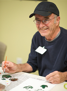 a man smiling and painting