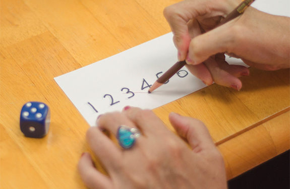 a person using a pencil on a number puzzle