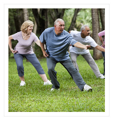 group of older adults performing tai chi in a park
